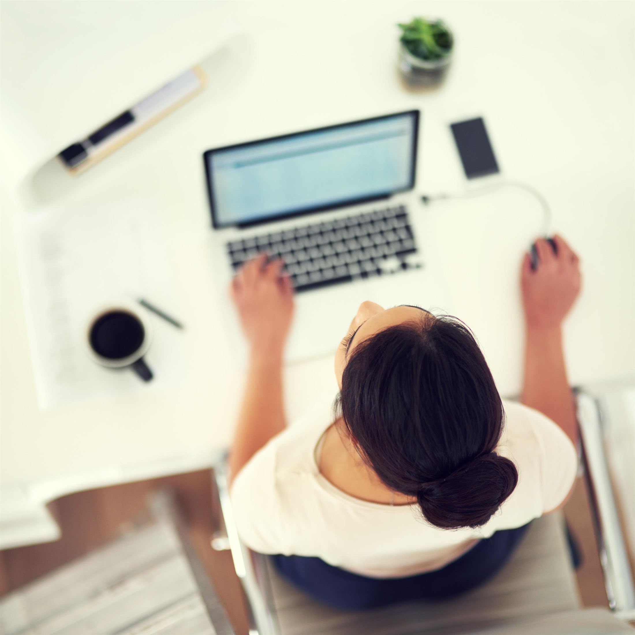 A consultant working at a laptop with coffee close at hand