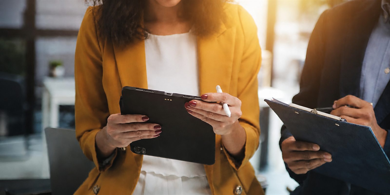 A Poise consultant reviewing notes on a tablet during a client conversation